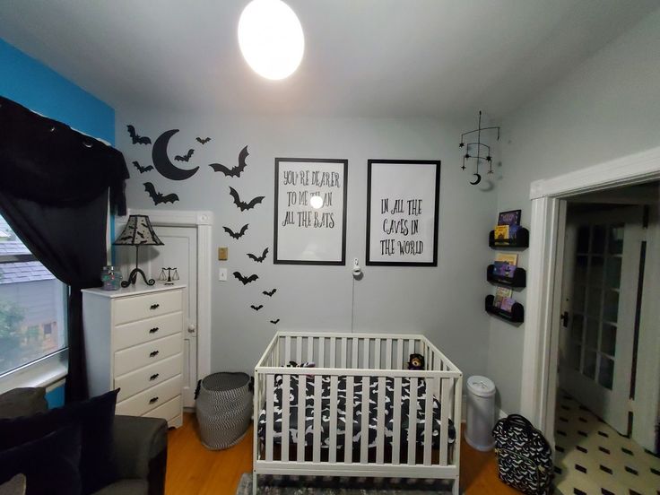 a baby's room decorated in black and white, with bats on the wall