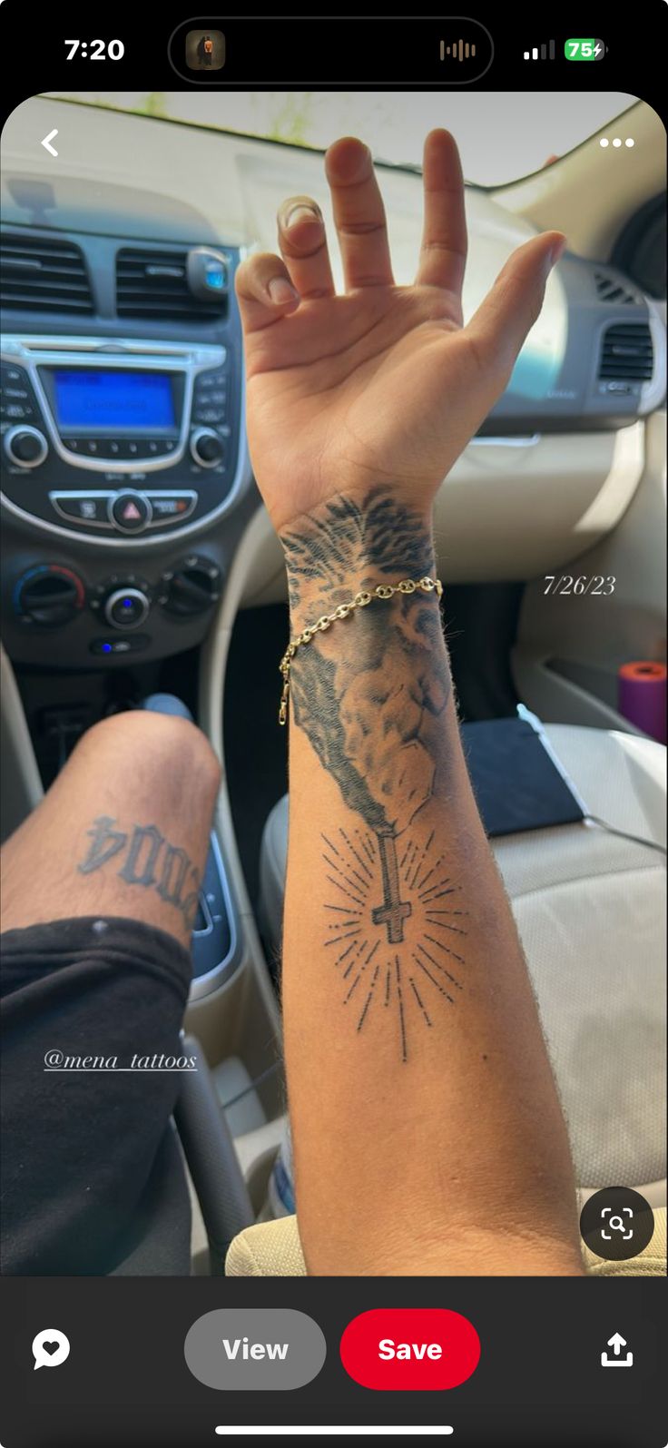 a person holding their hand up in the air with a tattoo on it's arm