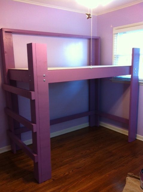 a purple bunk bed sitting on top of a hard wood floor next to a window