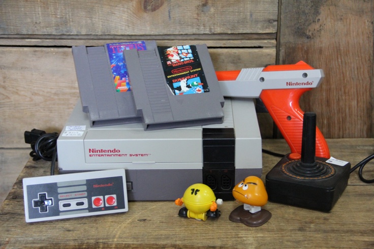 an old nintendo game system with two rubber toys and a video game controller sitting next to it