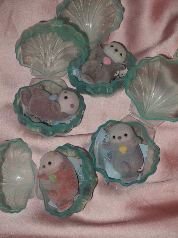 six glass dishes with animals in them on a pink cloth