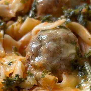 a close up view of some food with broccoli and meatballs in it