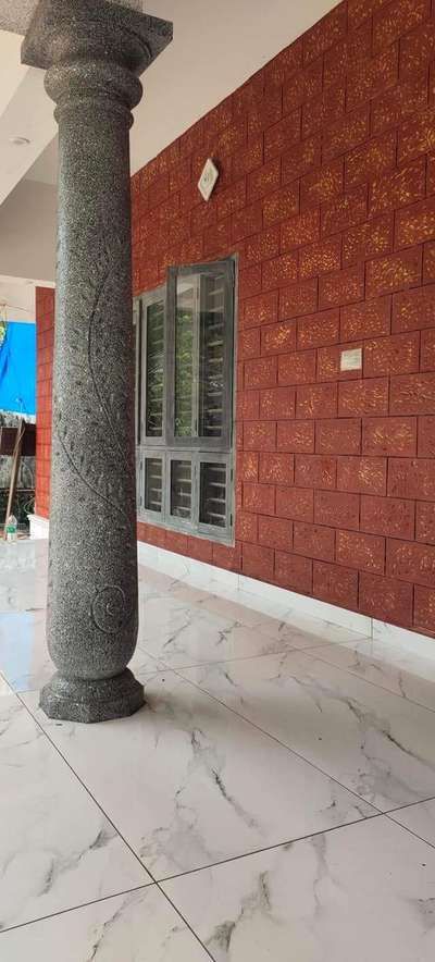 a large pillar in front of a building with red bricks on the wall and windows