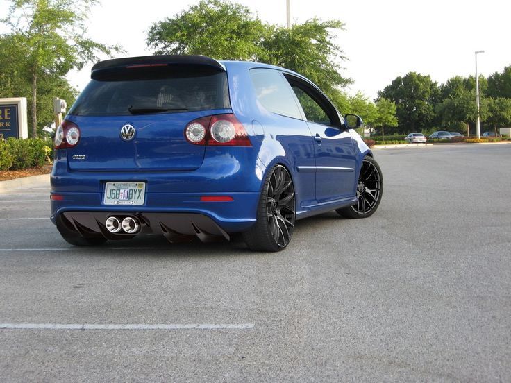 the back end of a blue car parked in a parking lot