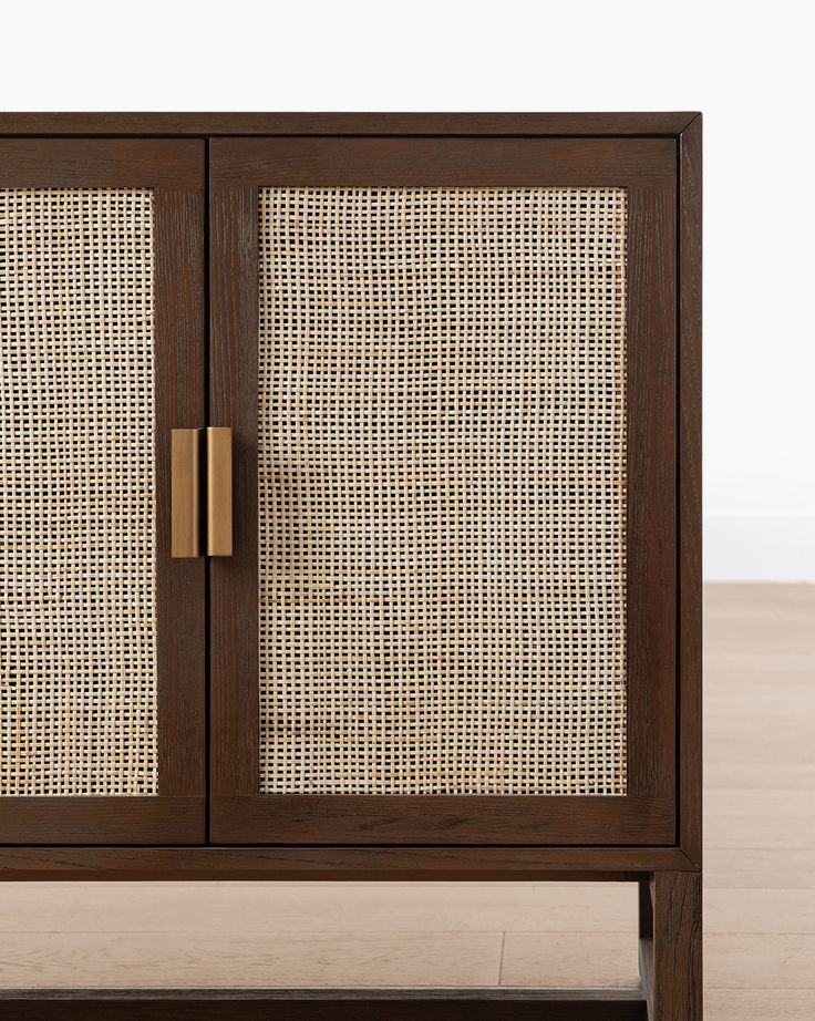 a wooden cabinet with woven doors and handles