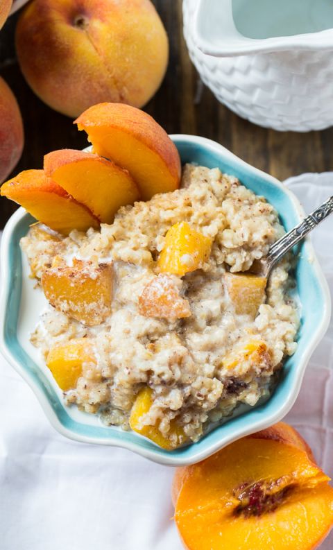 a bowl of oatmeal with peaches on the side