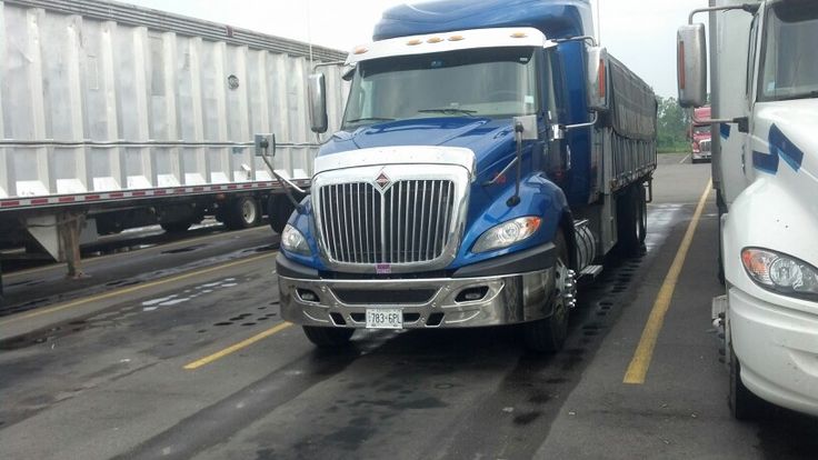 two semi trucks driving down the road next to each other