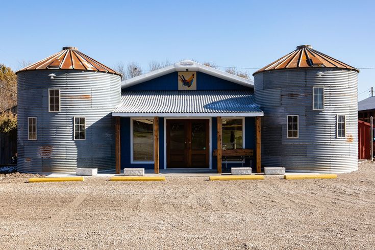 an old grain silos sits in the middle of a dirt lot