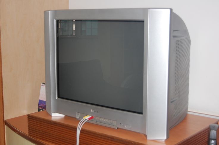 an old tv sitting on top of a wooden shelf