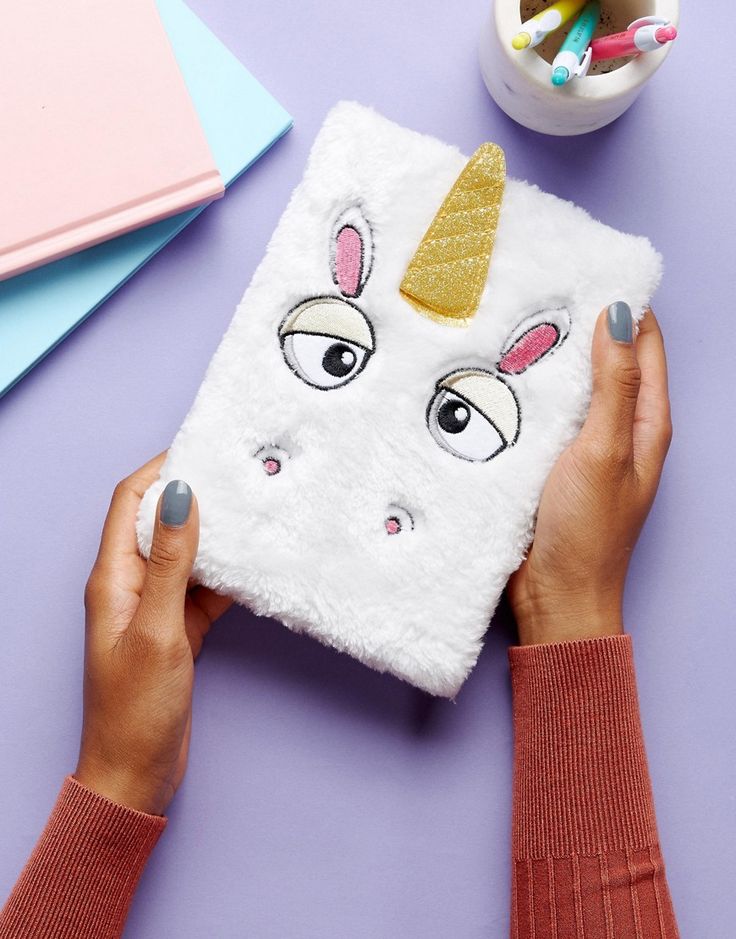 someone is holding up a white case with a unicorn face on it