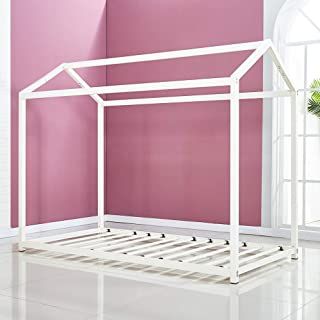 a white metal bed frame against a pink wall in a room with tile flooring