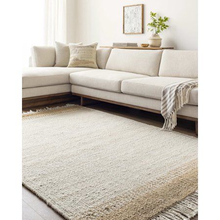 a living room with a white couch and rug