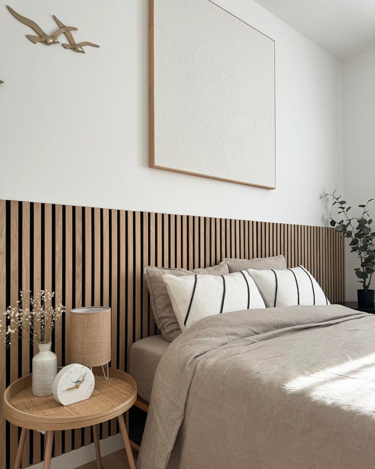 a bedroom with a bed, side table and pictures on the wall above it that is decorated in black and white stripes