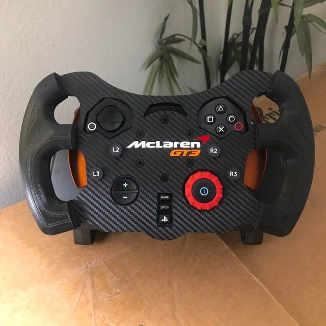 a close up of a steering wheel on a cardboard box with plants in the background