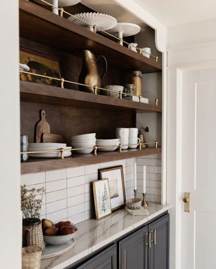 a kitchen with open shelving and plates on the counter