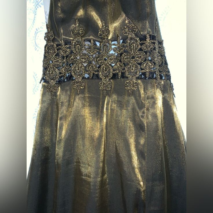 the dress is gold and has black lace on it