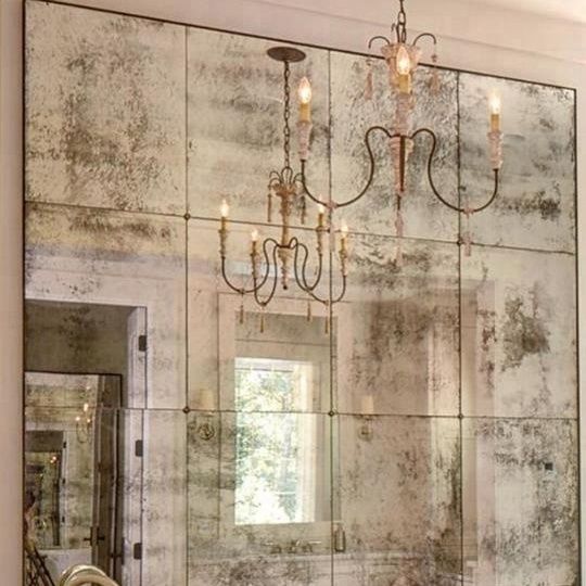 a bathroom with a large mirror and chandelier hanging from it's ceiling