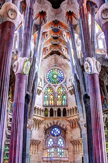 the inside of a building with many tall pillars and stained glass windows on each side