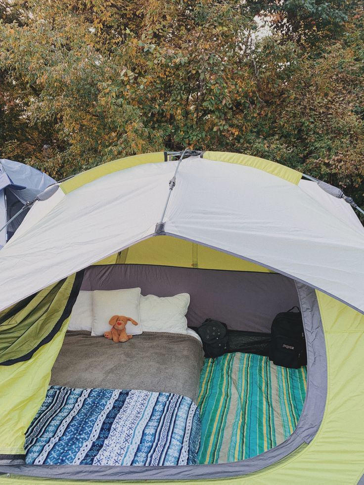 an open tent with pillows and blankets inside