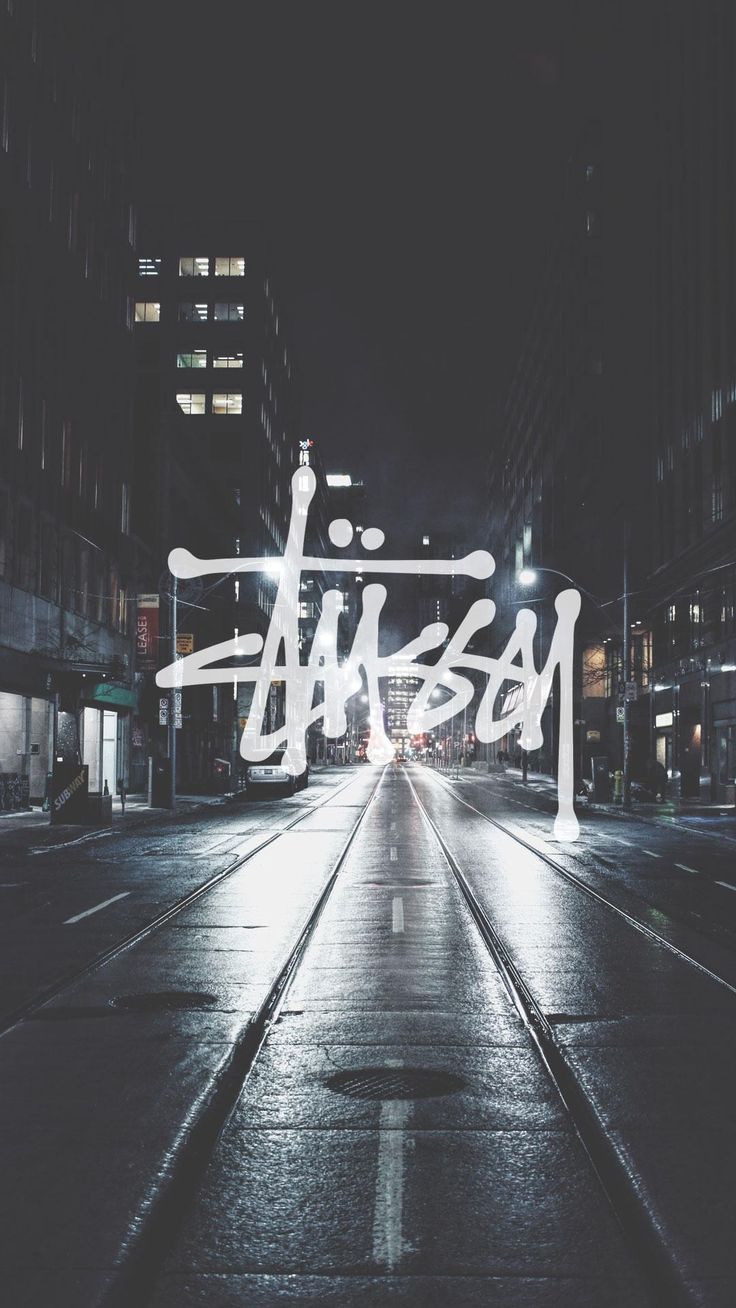 a city street at night with graffiti written on it