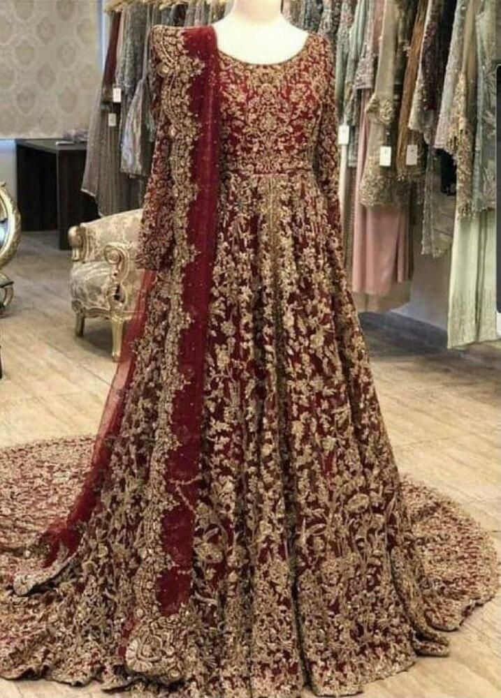 a red and gold wedding gown on display in a store with mannequins