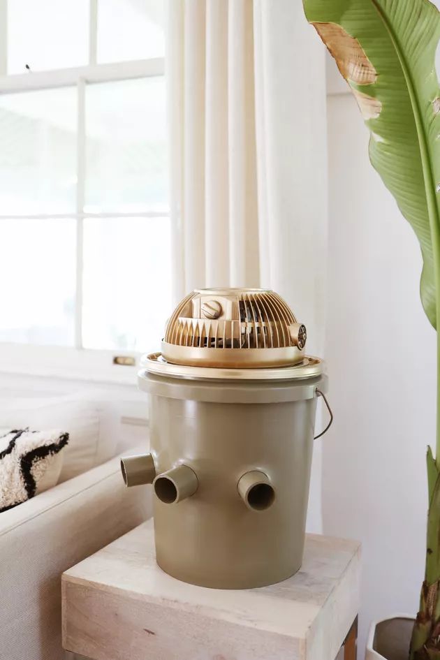 an air conditioner sitting on top of a table next to a plant