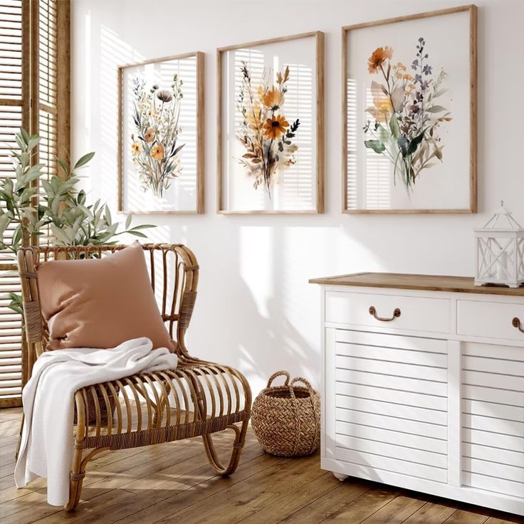 a room with three framed pictures on the wall and a wicker chair next to it