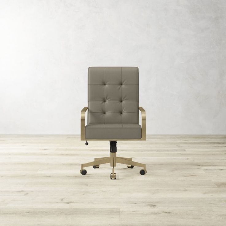 an office chair sitting on top of a hard wood floor next to a white wall