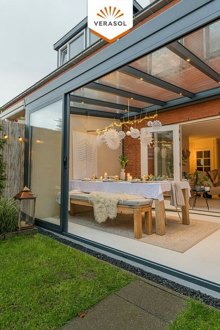 an outside dining room and patio area with glass walls