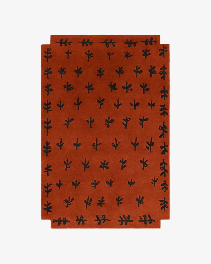 an orange and black rug with small cactus designs on the front, against a white background