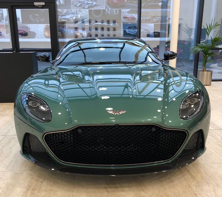 a green sports car parked in front of a building