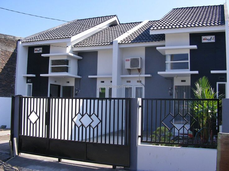 three houses with black and white railings on the front, one has an iron gate