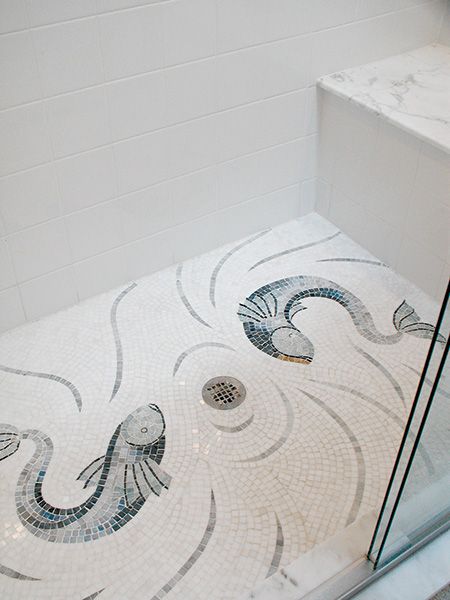 a bathroom with a glass shower door and tiled floor