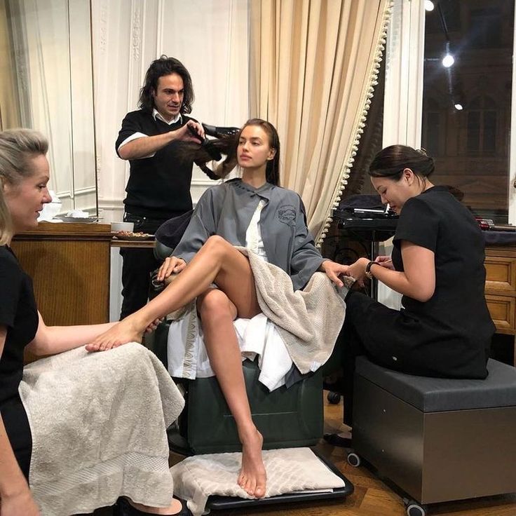 the woman is getting her hair done while others look on in the mirror behind them