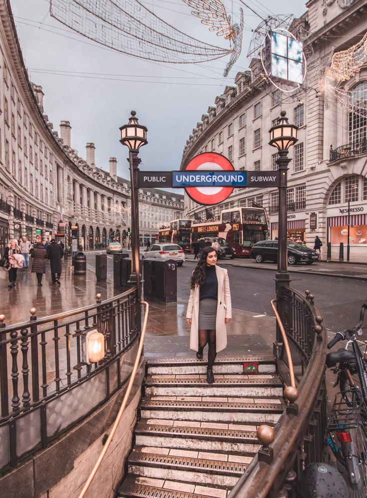 a woman is walking down the stairs in london