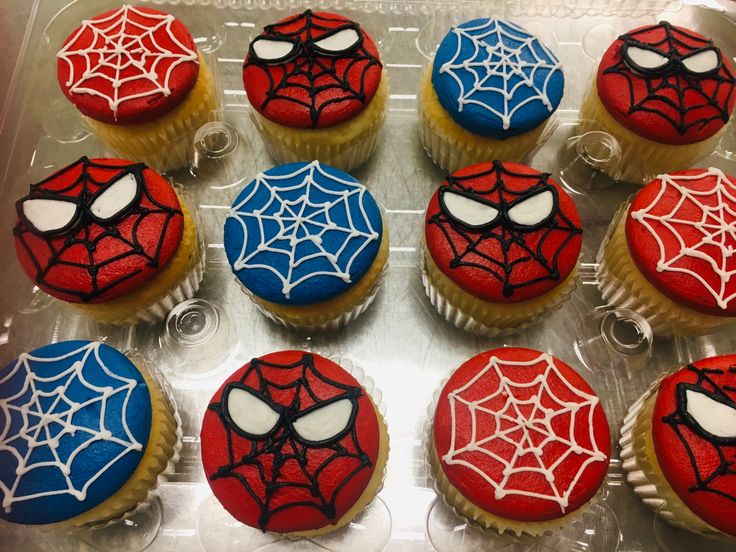 cupcakes decorated with spider - man icing are on display