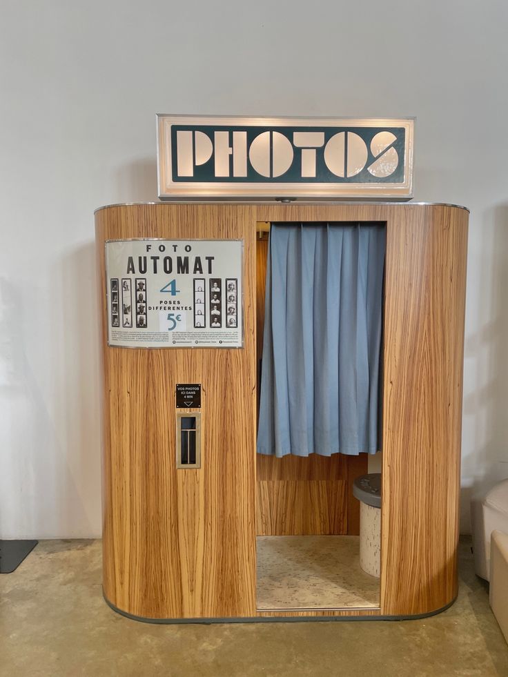 an old fashioned photo booth with curtains and a sign on the door that says automat