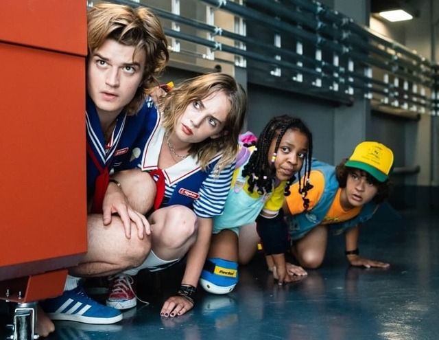 five young people are leaning against a wall