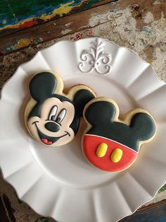 a mickey mouse cookie sitting on top of a white plate