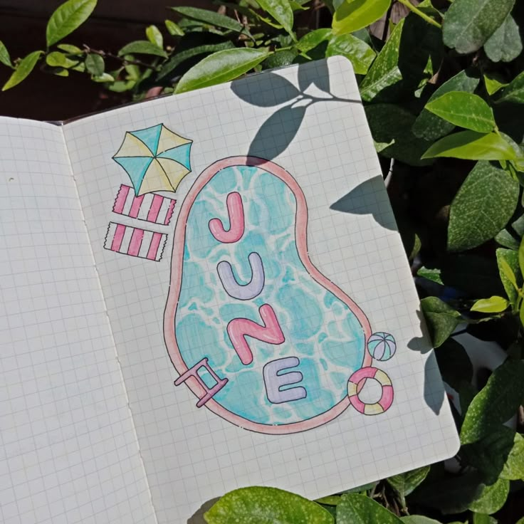 an open notebook sitting on top of a green leafy plant with the word sushi written in it