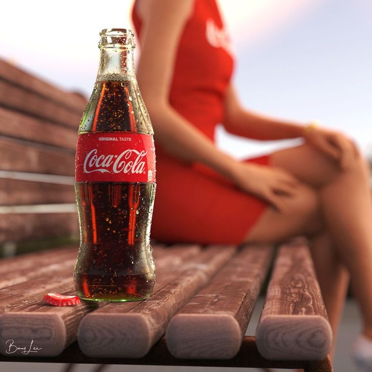 a woman sitting on a bench next to a bottle of coca - cola in front of her