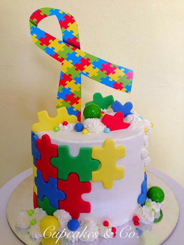 a birthday cake decorated with colorful puzzle pieces