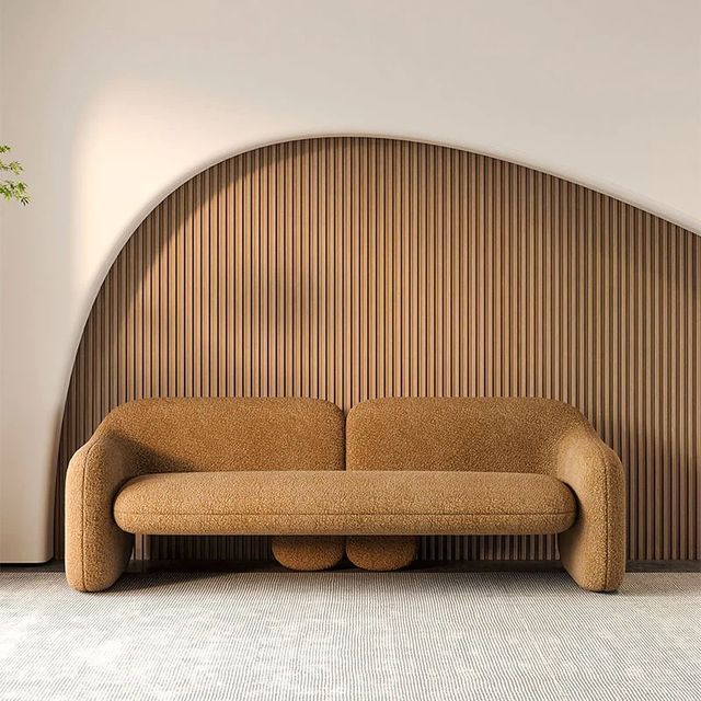 a brown couch sitting in front of a wooden headboard on a white carpeted floor