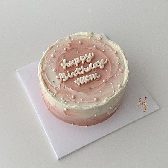 a birthday cake with white frosting and pink icing