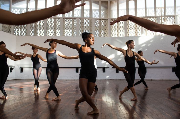 a group of women in black leotards are doing dance moves with their hands