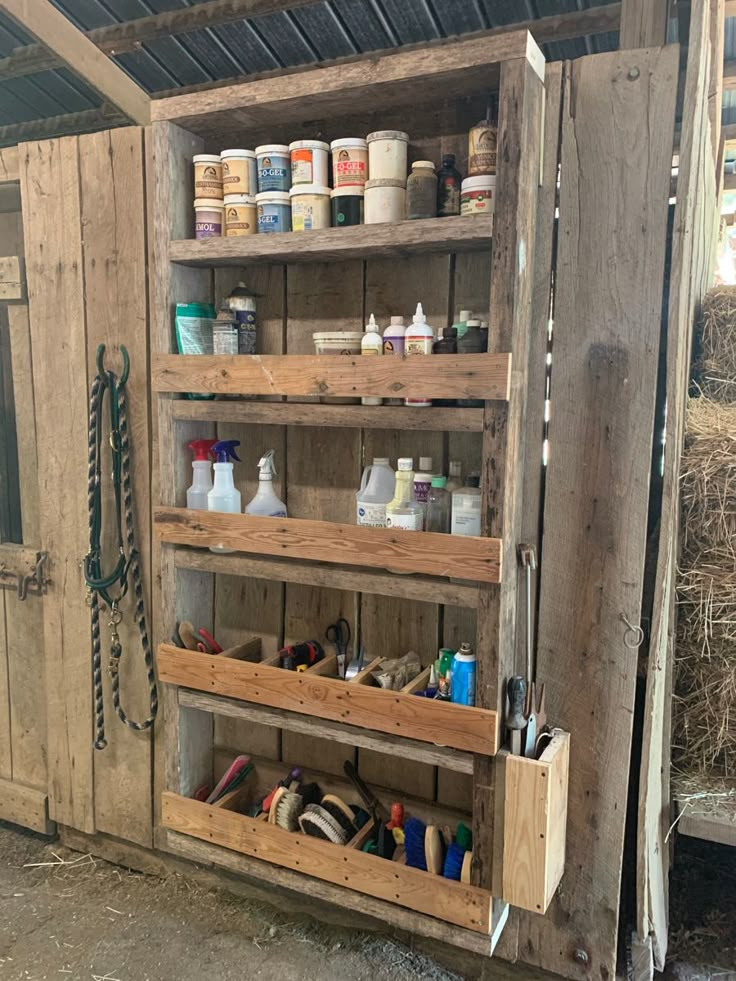 the inside of a wooden shed with shelves filled with paint and other items in it