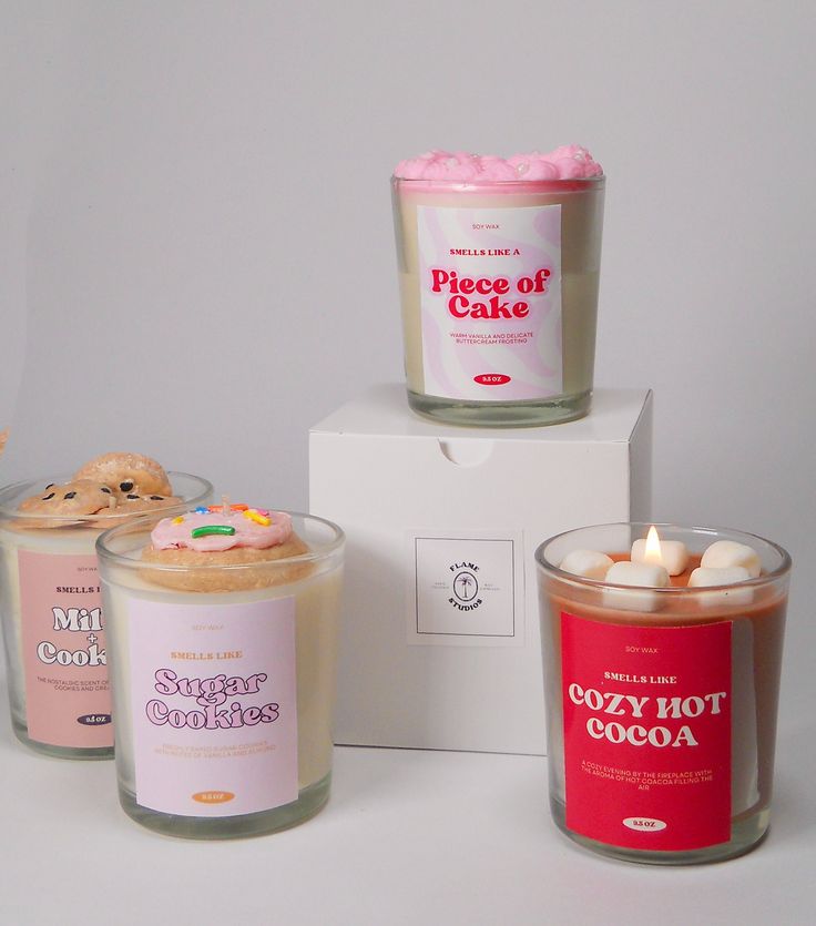 three candles sitting next to each other in front of a box with cookies on it