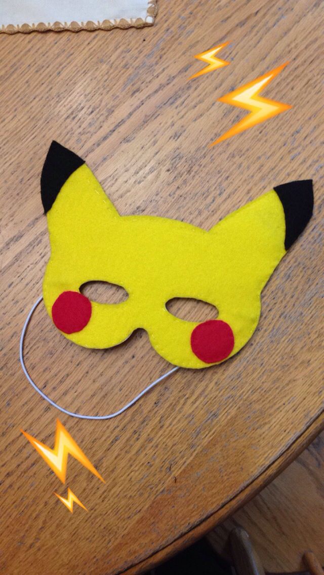 a yellow cat mask sitting on top of a wooden table next to an electrical wire