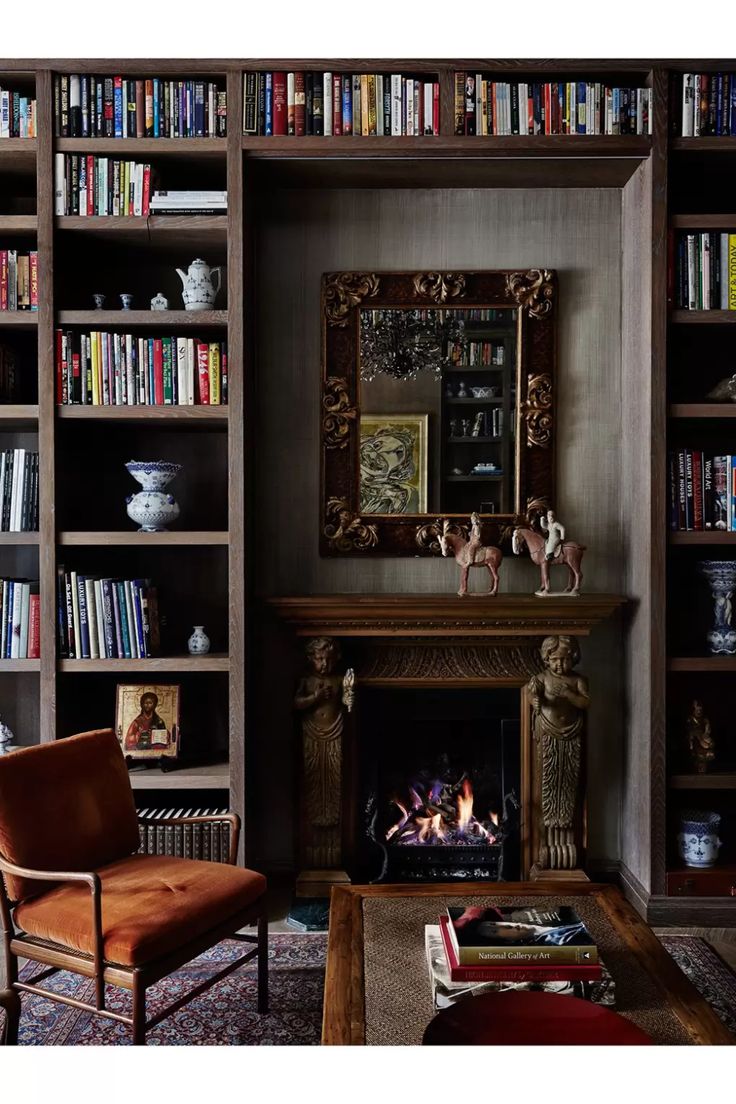 a living room filled with furniture and a fire place next to a bookshelf