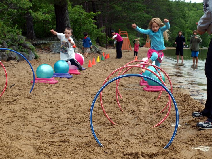 several children playing in the sand with toys